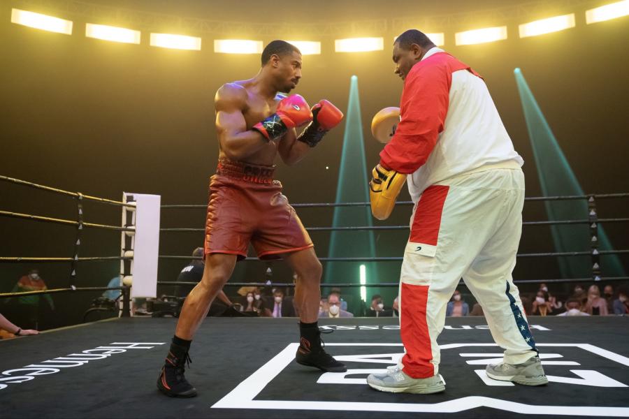 Image from the film Creed III featuring Boog training Michael B. Jordan in a boxing ring.